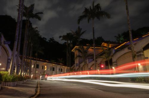 a city street with buildings and palm trees at night at Regale Motel in Zhonghe