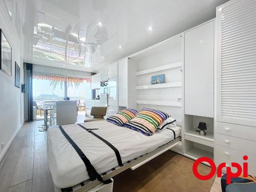 une chambre avec un grand lit avec des oreillers dessus dans l'établissement Studio rénové avec terrasse, climatisation et parking à Menton - FR-1-647-42, à Menton