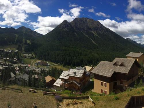 un petit village avec une montagne en arrière-plan dans l'établissement Studio 4 pers sud avec balcon, parking et animaux acceptés - FR-1-445-206, à Montgenèvre