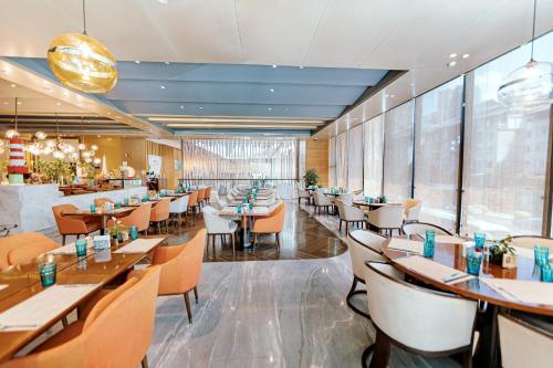 a dining room with tables and chairs in a restaurant at Crowne Plaza Yibin by IHG in Yibin
