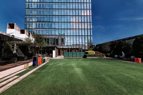 a green lawn in front of a tall building at Crowne Plaza Yibin by IHG in Yibin