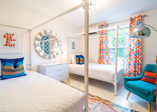 a bedroom with two beds and a blue chair at Twin Gables of Woodstock in Woodstock