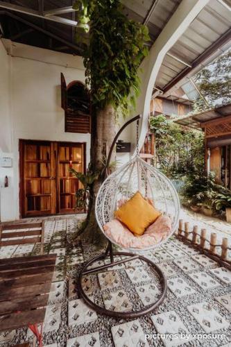 a chair with a pillow sitting on a patio at Tirtha Quddus Farm Stay in Kampong Sum Sum