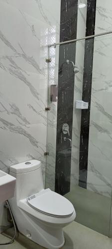 a bathroom with a toilet and a glass shower at Dream Hills Villa in Batu