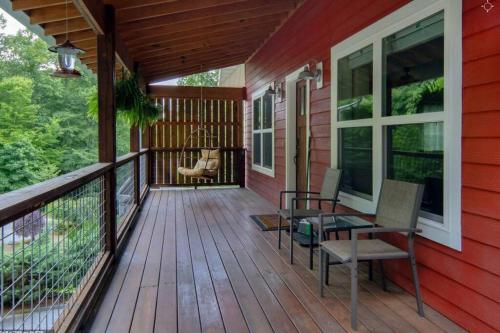 a deck with a table and chairs on a red house at River Rock Cabin - Comfortable, Private Home with King Beds & Mountain Views in Horse Shoe