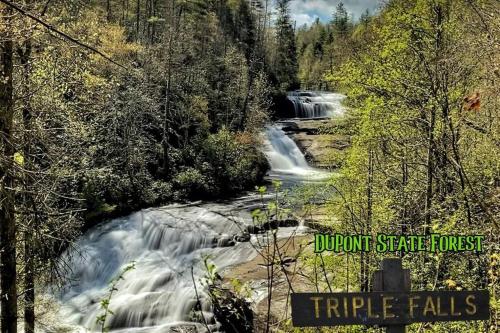 a waterfall in the middle of a river with trees at River Rock Cabin - Comfortable, Private Home with King Beds & Mountain Views in Horse Shoe
