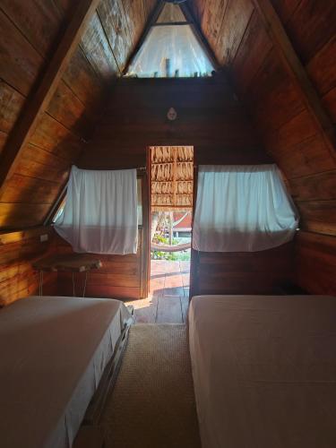 a attic bedroom with two beds and a window at Eco Cabañas Keiki Kai in Sipacate