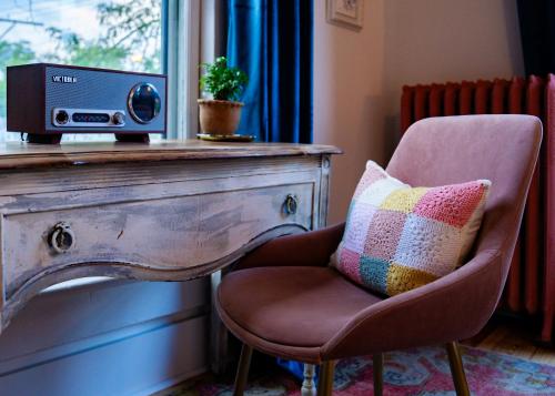 a chair with a pillow and a speaker on a table at Twin Gables of Woodstock in Woodstock