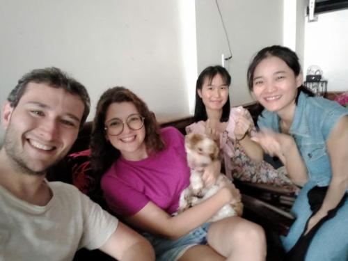 a group of people sitting on a couch with a dog at Hue Lovely Homestay in Hue