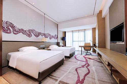 a hotel room with two beds and a flat screen tv at Crowne Plaza Yibin by IHG in Yibin