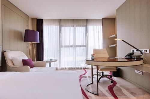 a hotel room with a bed and a desk and chair at Crowne Plaza Yibin by IHG in Yibin