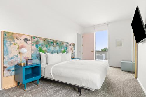 a bedroom with a large bed and a blue table at The Doyle Hotel in Charlottesville