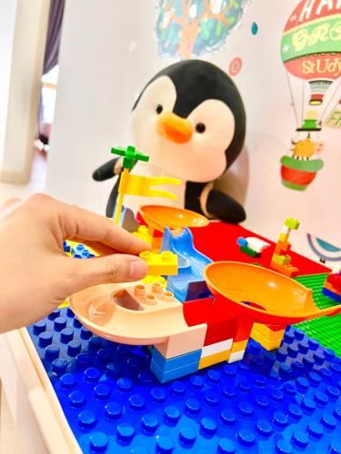 a child playing with a lego toy of a toy penguin at Legoland-4mins Walk-Spacious-Kids Friendly with Bathtub@ Happy Travel- AFINITY RESIDENCY in Nusajaya