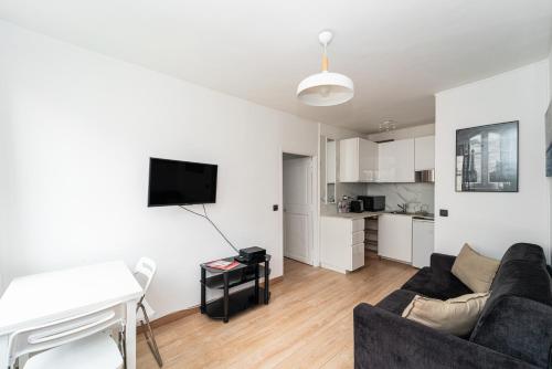 un salon avec un canapé et une table dans l'établissement Charmant 2 pièces à 2 pas du Marais, à Paris