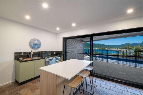 a kitchen with a large window with a view at Day Dreaming - Mazlin House in Airlie Beach