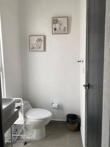 a white bathroom with a toilet and a sink at Casa de descanso in Veracruz