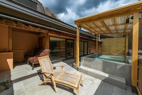 a patio with a swimming pool and a wooden pergola at Myojinkan in Matsumoto