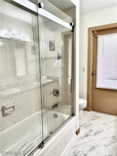 a bathroom with a shower and a sink and a toilet at Beautiful 3 Bed House with pool in North Fort Myers
