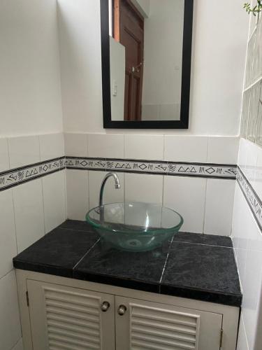 a bathroom with a green glass sink and a mirror at Hermosa habitación independiente cerca a Miraflores in Lima