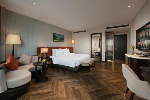 a hotel room with a bed and a living room at Le Premier Hotel & Rooftop Bar in Hanoi