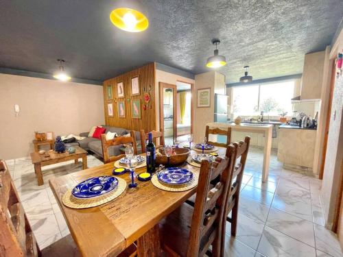 a kitchen and living room with a wooden table and chairs at Departamento Vista Lago de Pátzcuaro in Pátzcuaro