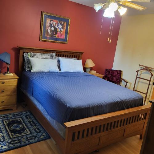 a bedroom with a bed with a blue comforter at My Home in Calgary