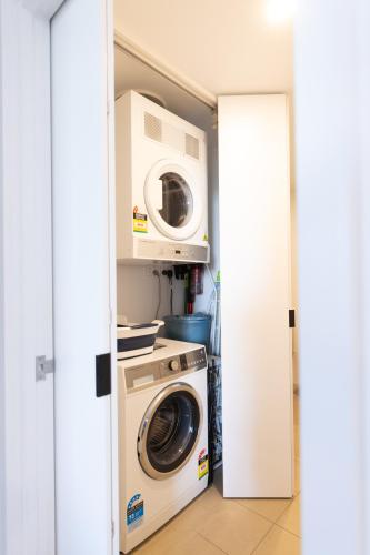 a laundry room with a washer and dryer at Spectacular views, king bd plus single bed & parking in Brisbane