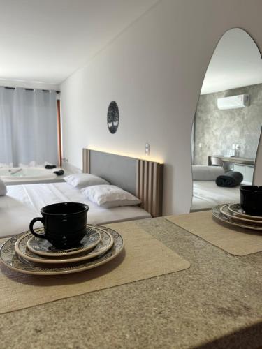 a hotel room with two beds with coffee cups on a table at Villa Mavi - Praia do Rosa in Imbituba