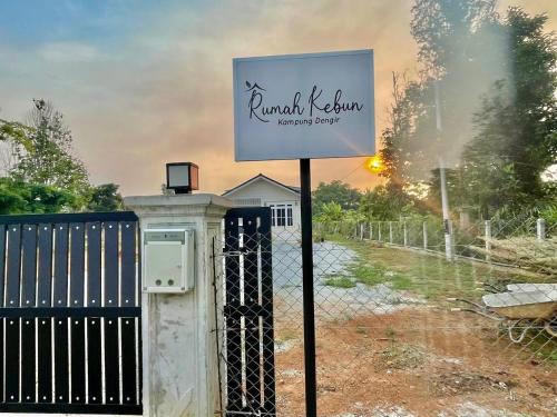 a sign in front of a fence next to a gate at Rumah Kebun, Jerteh Besut in Kampung Dengir