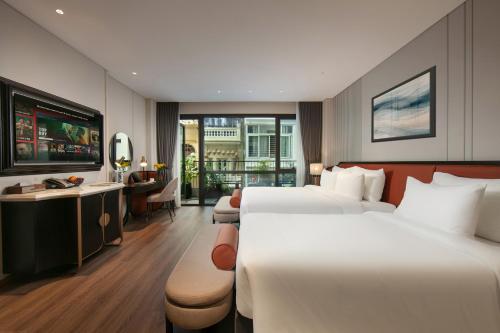 a hotel room with two beds and a desk at Le Premier Hotel & Rooftop Bar in Hanoi