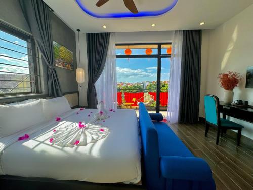 a bedroom with a white bed and a blue couch at PHỐ CHỢ ĐÊM Villa - Near Hoi An Old Town 200m in Hoi An