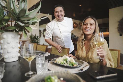 a man and woman sitting at a table with a plate of food at Trobbu Boutique Collection Tulum - All inclusive in Tulum