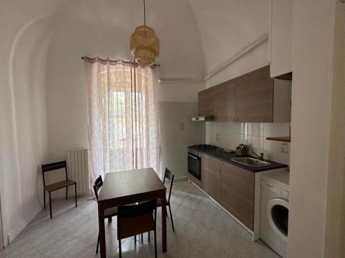 cocina con mesa, fregadero, mesa y sillas en Giovinazzo Suite Antico Portale, en Giovinazzo