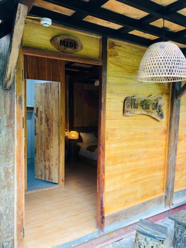 an open door of a wooden building with a sign at Nhà của Mỵ in Làng Vat