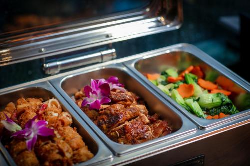 two trays of food with vegetables in a refrigerator at Le Premier Hotel & Rooftop Bar in Hanoi