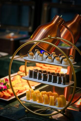 a display of sushi on three plates in front of a fire at Le Premier Hotel & Rooftop Bar in Hanoi