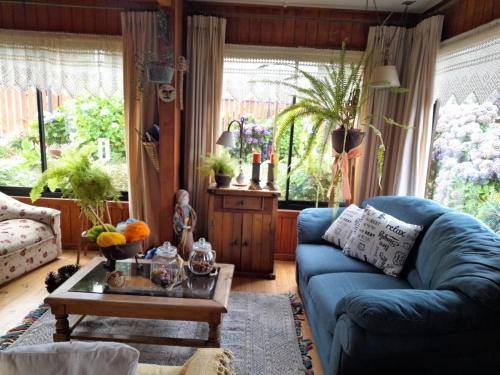 a living room with a blue couch and a table at Casa Lago Ranco in Lago Ranco