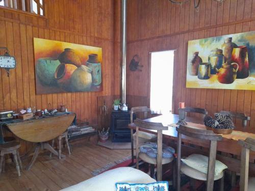 a room with tables and chairs and paintings on the wall at Casa Lago Ranco in Lago Ranco