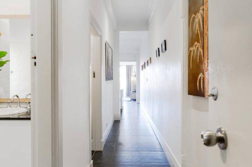 a hallway with white walls and a tile floor at Beachfront Building on Bondi Beach in Sydney