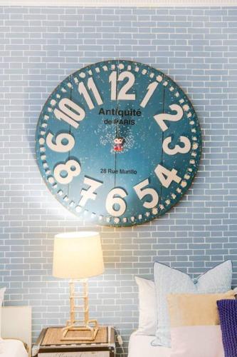 a large clock hanging on a wall above a couch at Beachfront Building on Bondi Beach in Sydney