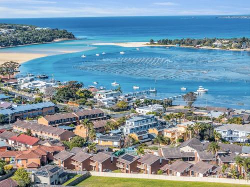 an aerial view of a coastal town with a harbor at Anchorbell Apartments Merimbula in Merimbula