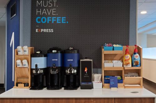 a counter with bottles of coffee on it at Holiday Inn Express & Suites Cincinnati Riverfront by IHG in Covington