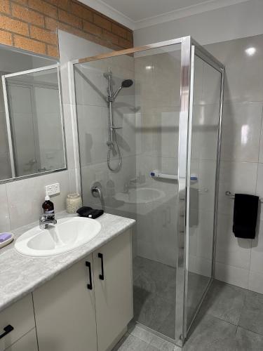a white bathroom with a shower and a sink at Lbarza Brand New Central 1BR Self Contained Apartment in Shepparton