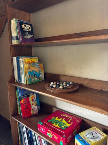 a book shelf filled with books and a plate of balls at Magical Malewa Retreat in Naivasha