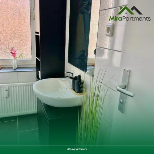 a bathroom with a white sink and a window at Lux Apartment im Rüttenscheid in Rüttenscheid