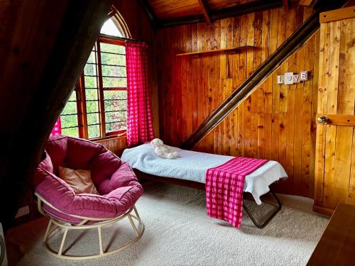 a room with a bed and a chair in a cabin at Magical Malewa Retreat in Naivasha