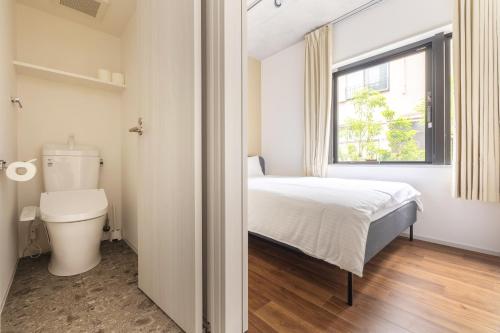 a bedroom with a bed and a toilet and a window at 67 Apt Kagurazaka Premium in Tokyo