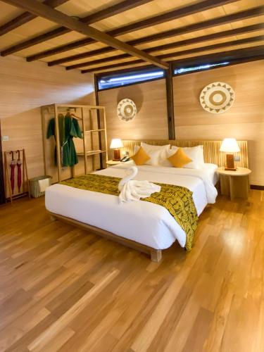 two beds in a room with wooden floors at Villa So Long Banyuwangi - Ijen in Banyuwangi