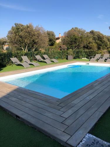 une grande piscine avec des chaises autour dans l'établissement Chez Muriel, à Porto-Vecchio