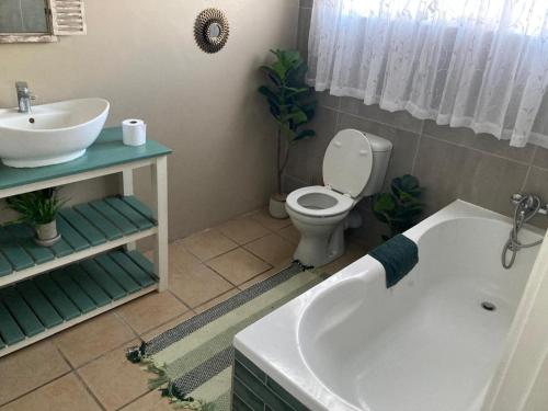 ein Badezimmer mit Badewanne, Toilette und Waschbecken in der Unterkunft 94 on Main in Kiddʼs Beach